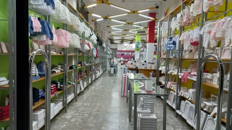 Interno del negozio New Bamby a Francavilla Fontana con gli scaffali dell'abbigliamento per bambini