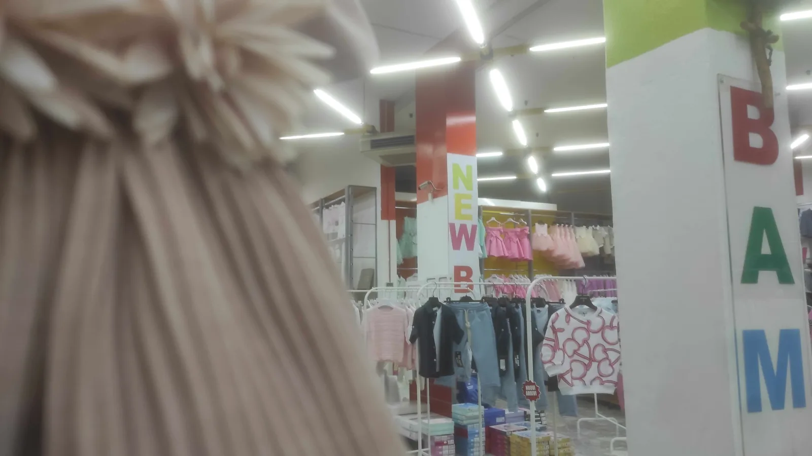 Abitini eleganti e capi da cerimonia nel reparto bambina del negozio New Bamby