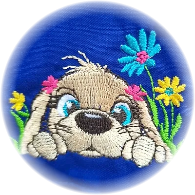 Ricamo di un cagnolino che sbuca tra i fiori colorati, su grembiule blu