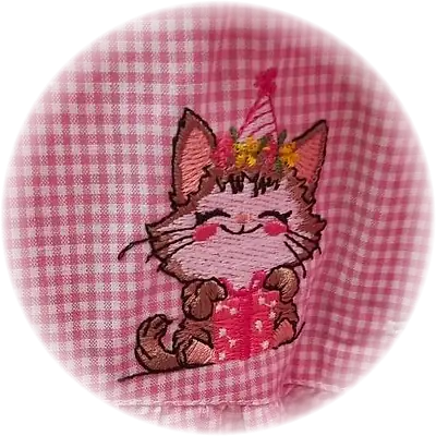 Ricamo di un gattino con cappellino di festa e regalo, su tessuto a quadretti rosa