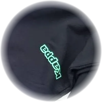 Dettaglio del logo Kappa verde menta ricamato sulla gamba del pantalone nero